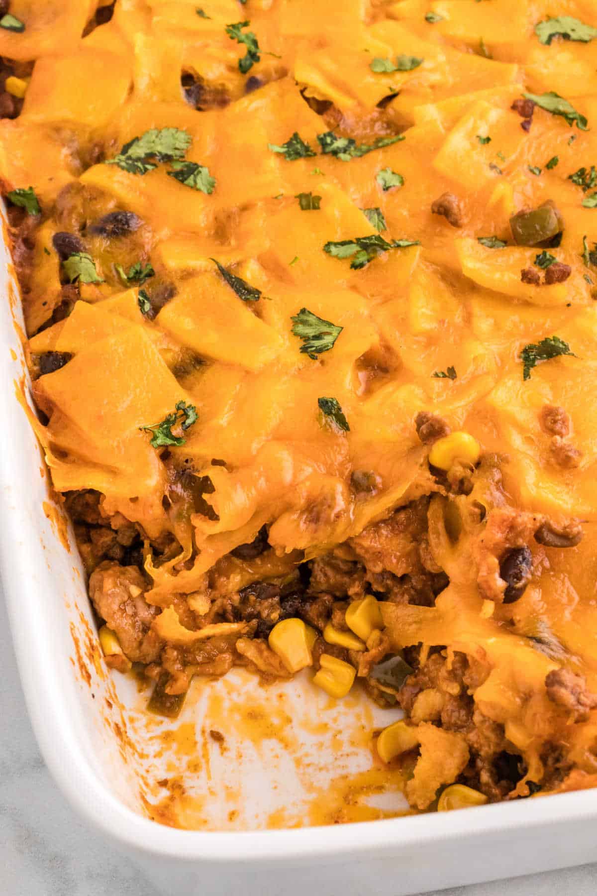Beef enchilada casserole with a piece missing.