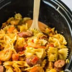 crockpot jambalaya pasta being scooped out of a slow cooker