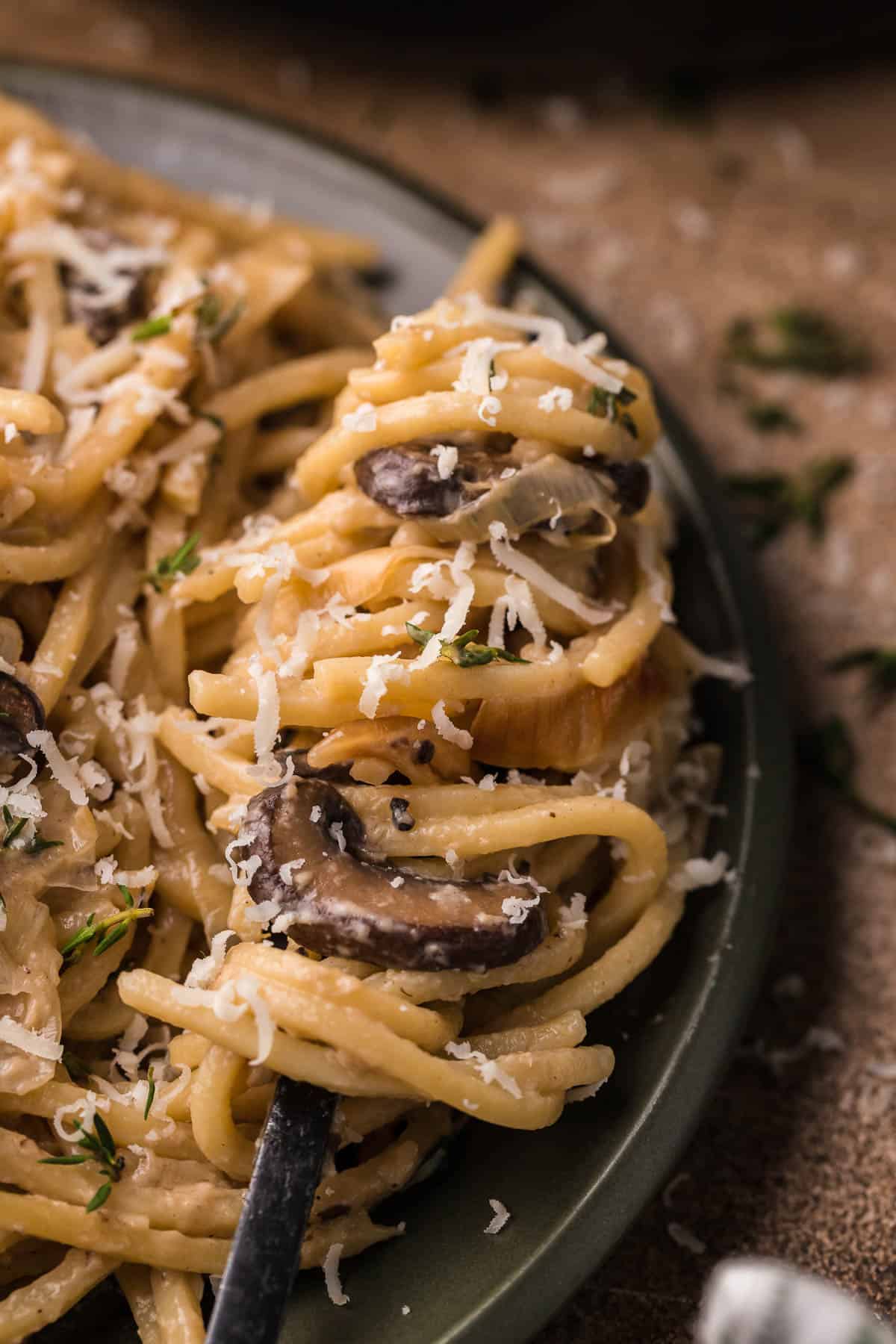 linguine swirled around a fork with mushrooms and parmesan cheese