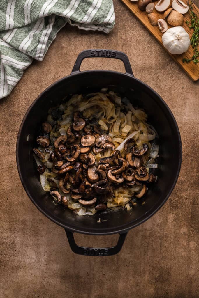 add roasted garlic to a cast iron pan with onions and mushrooms