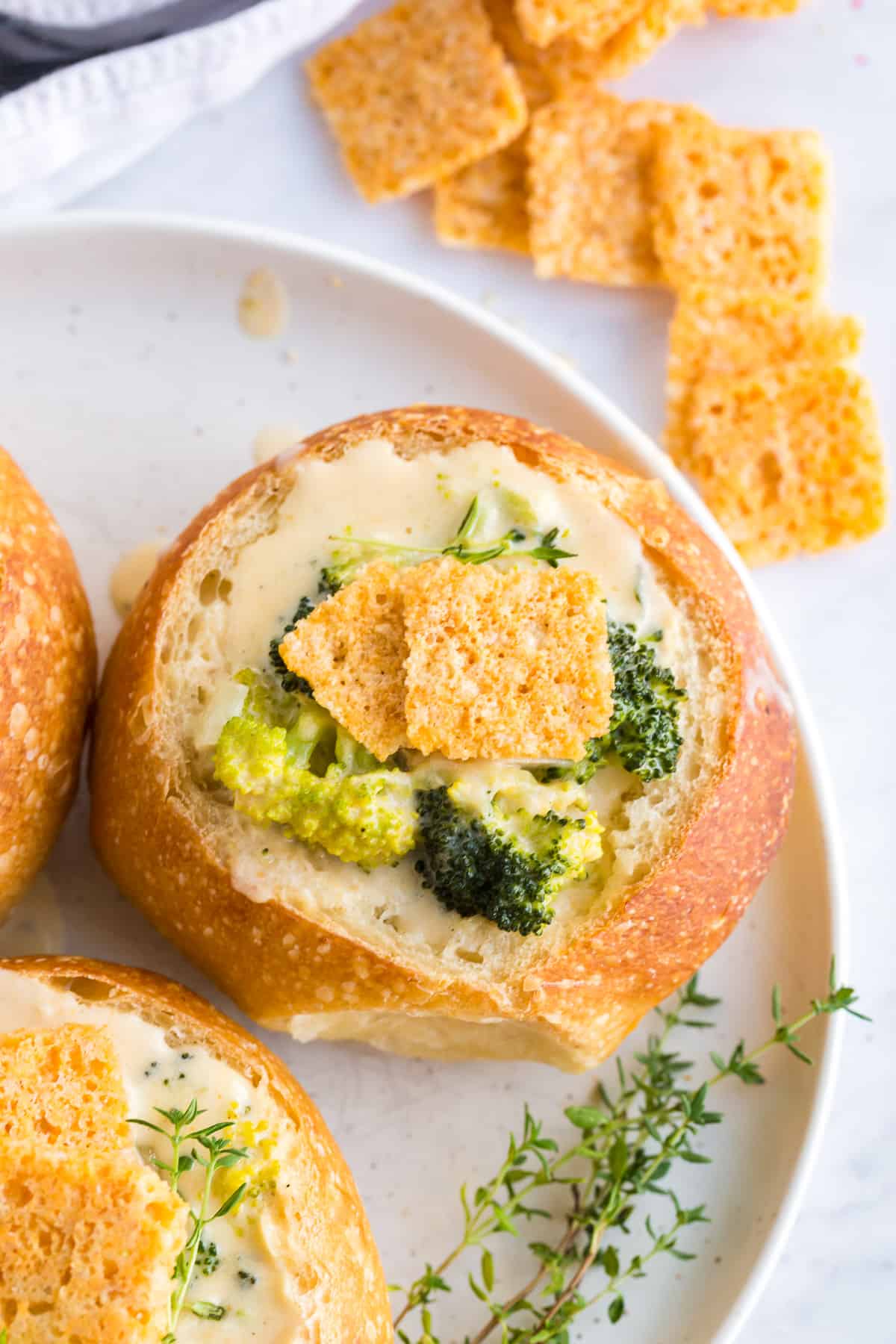 crackers made of baked cheddar cheese topping a creamy broccoli soup