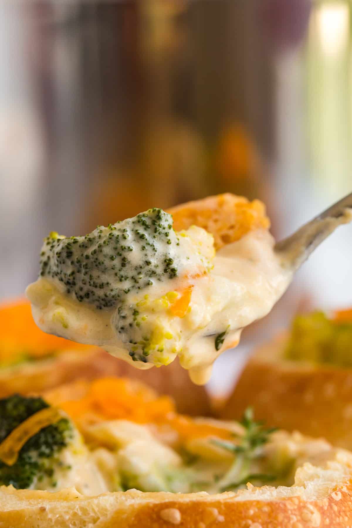 spoonful of creamy broccoli soup with a cheese cracker