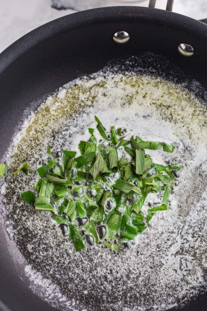 adding fresh sage to a brown butter base