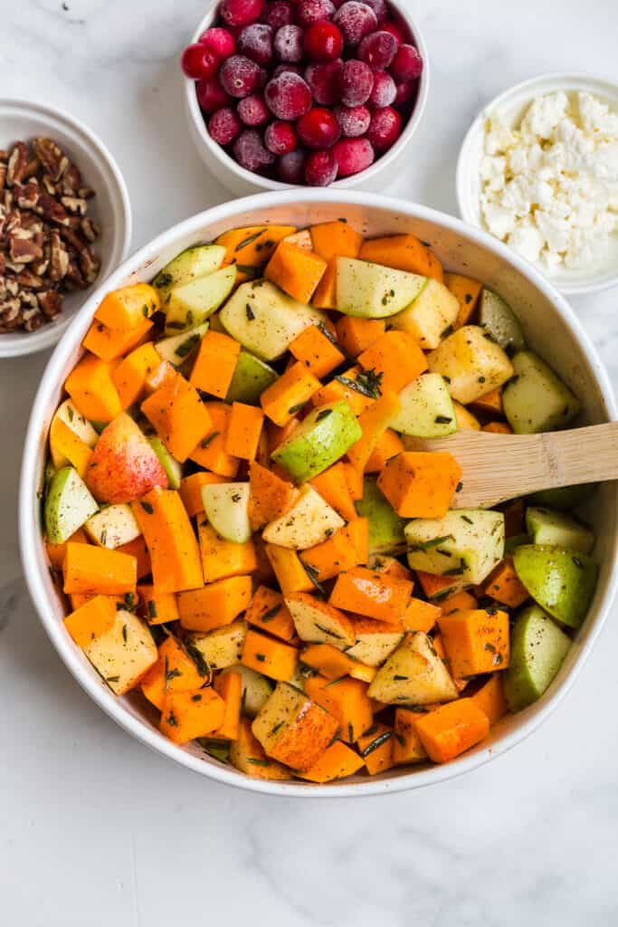 mixing together a citrus marinade and pouring over apples and butternut squash