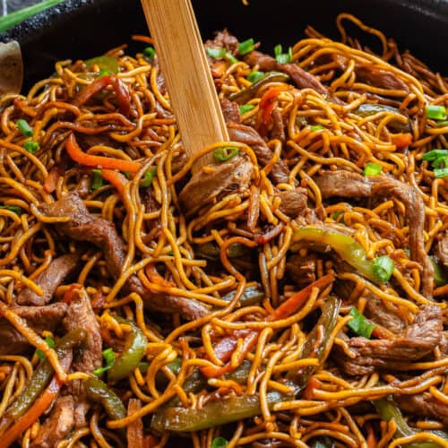 teriyaki beef noodle stir fry picked up with tongs