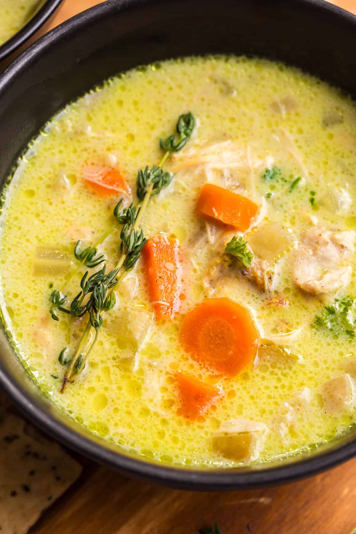 Close-up of chicken mulligatawny soup showing tender chicken, carrots, celery, and rice.