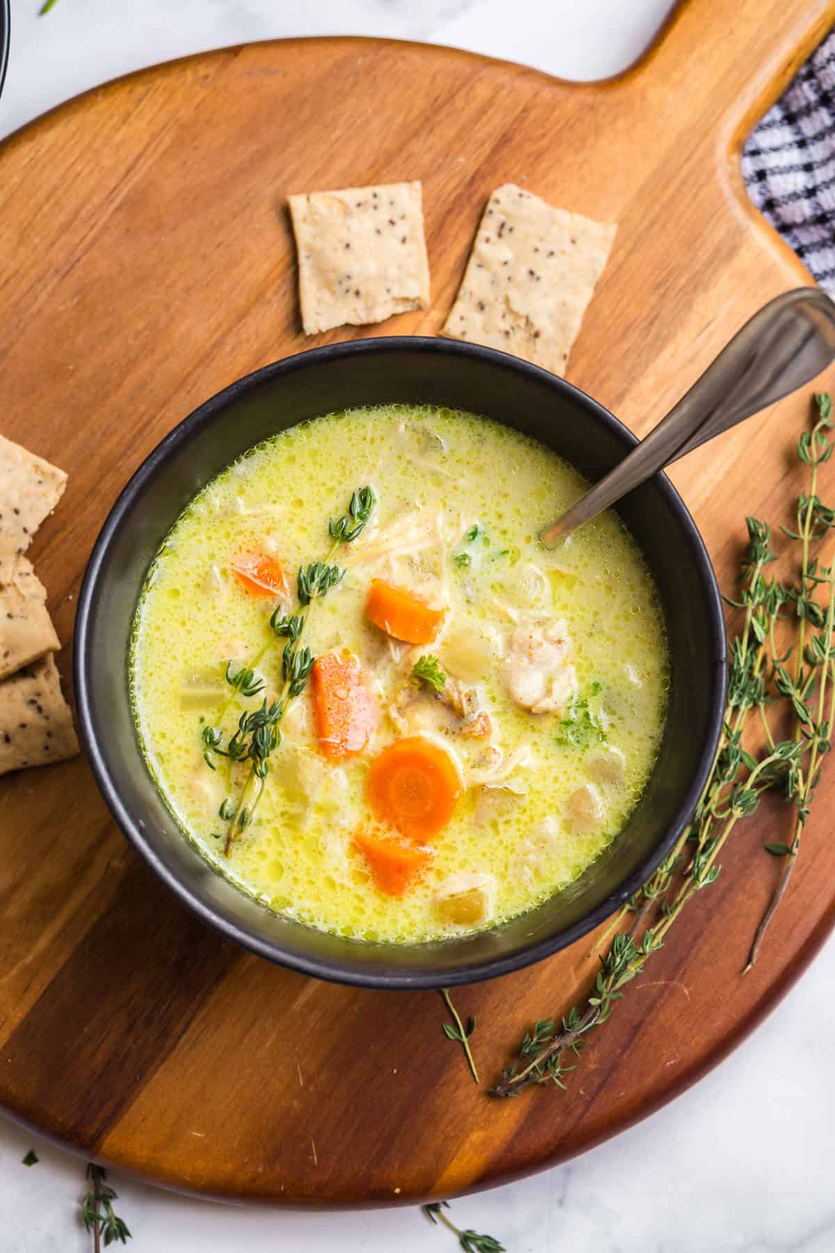 Slow cooker mulligatawny soup in a black bowl, topped with fresh thyme and served with crackers. Slow cooker mulligatawny soup in a black bowl, topped with fresh thyme and served with crackers.